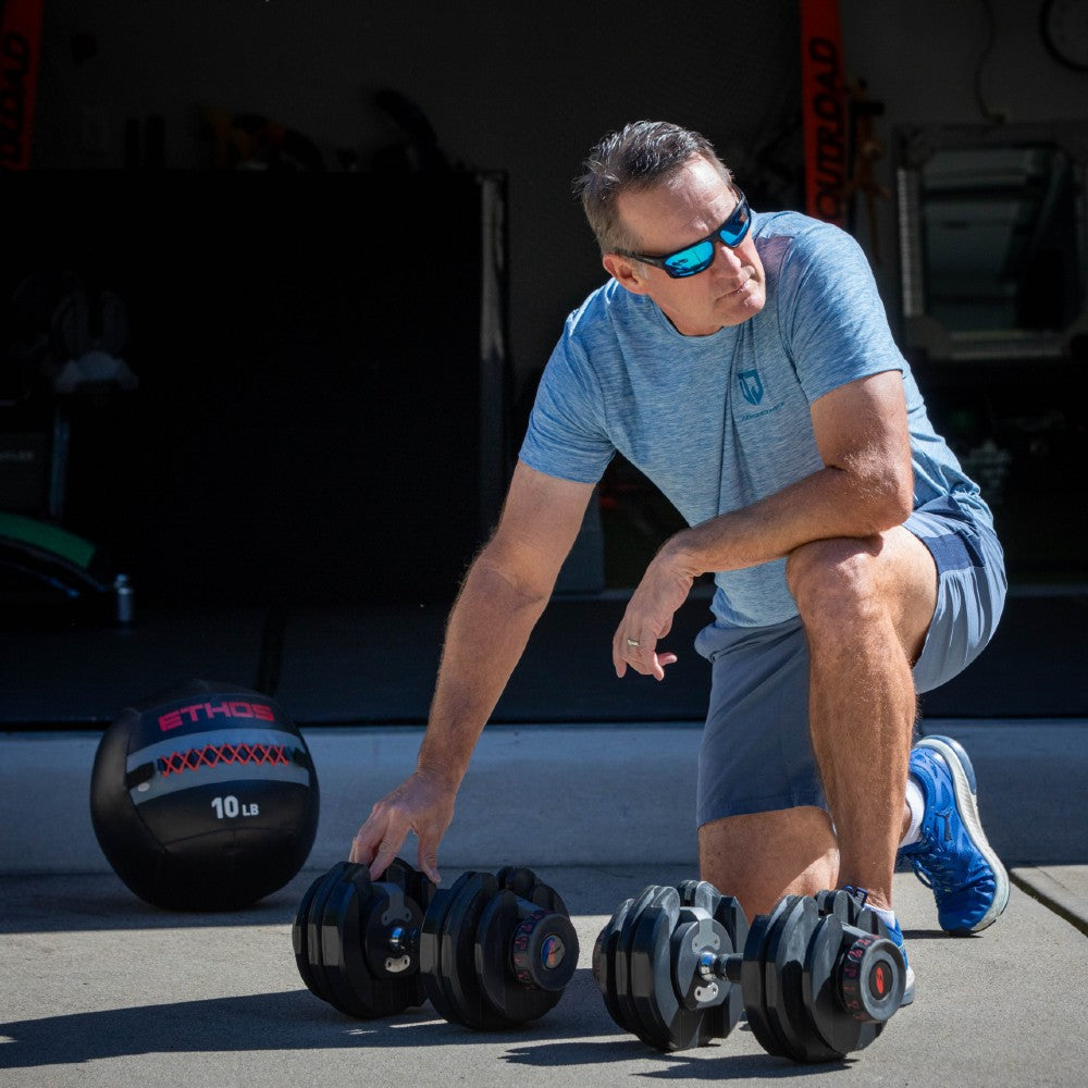 Dan Jansen lifting weights with focus and determination, representing the power and discipline behind JANSEN Eyewear